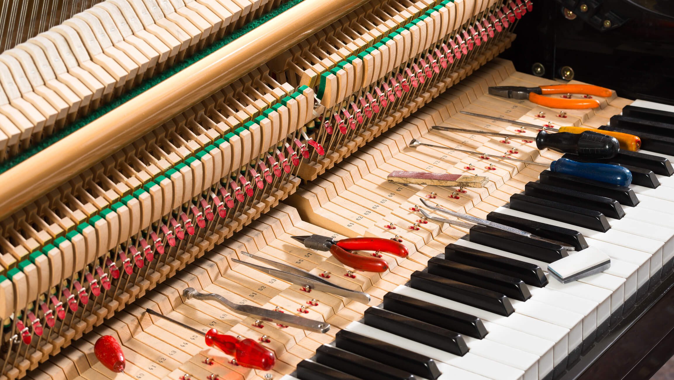 Open piano with repair tools