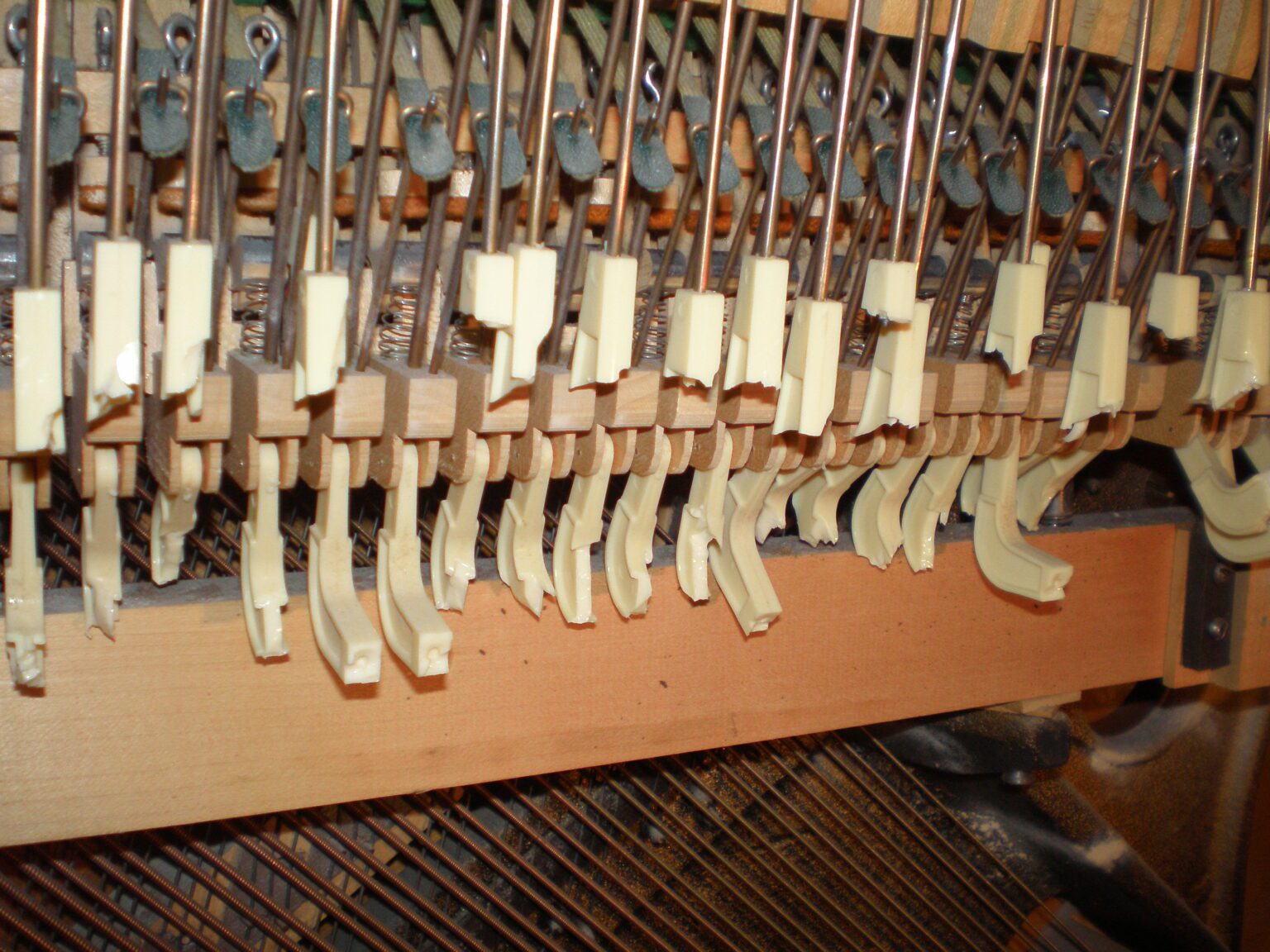 Close-up of piano hammers inside an upright piano.