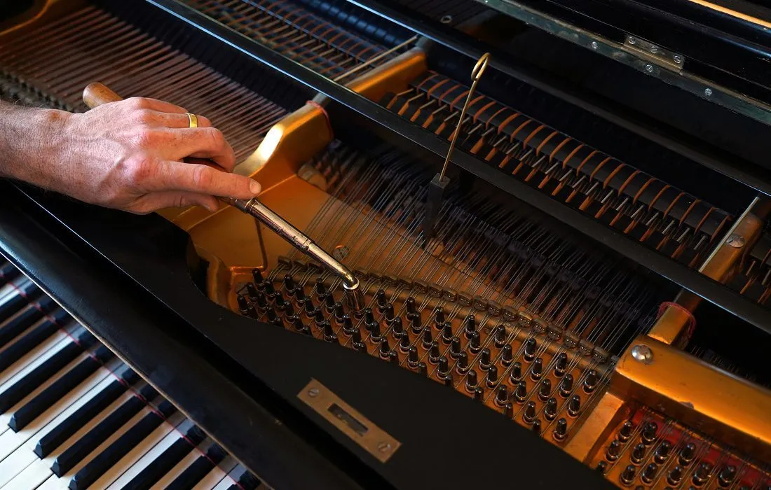 Piano technician tuning instrument expertly