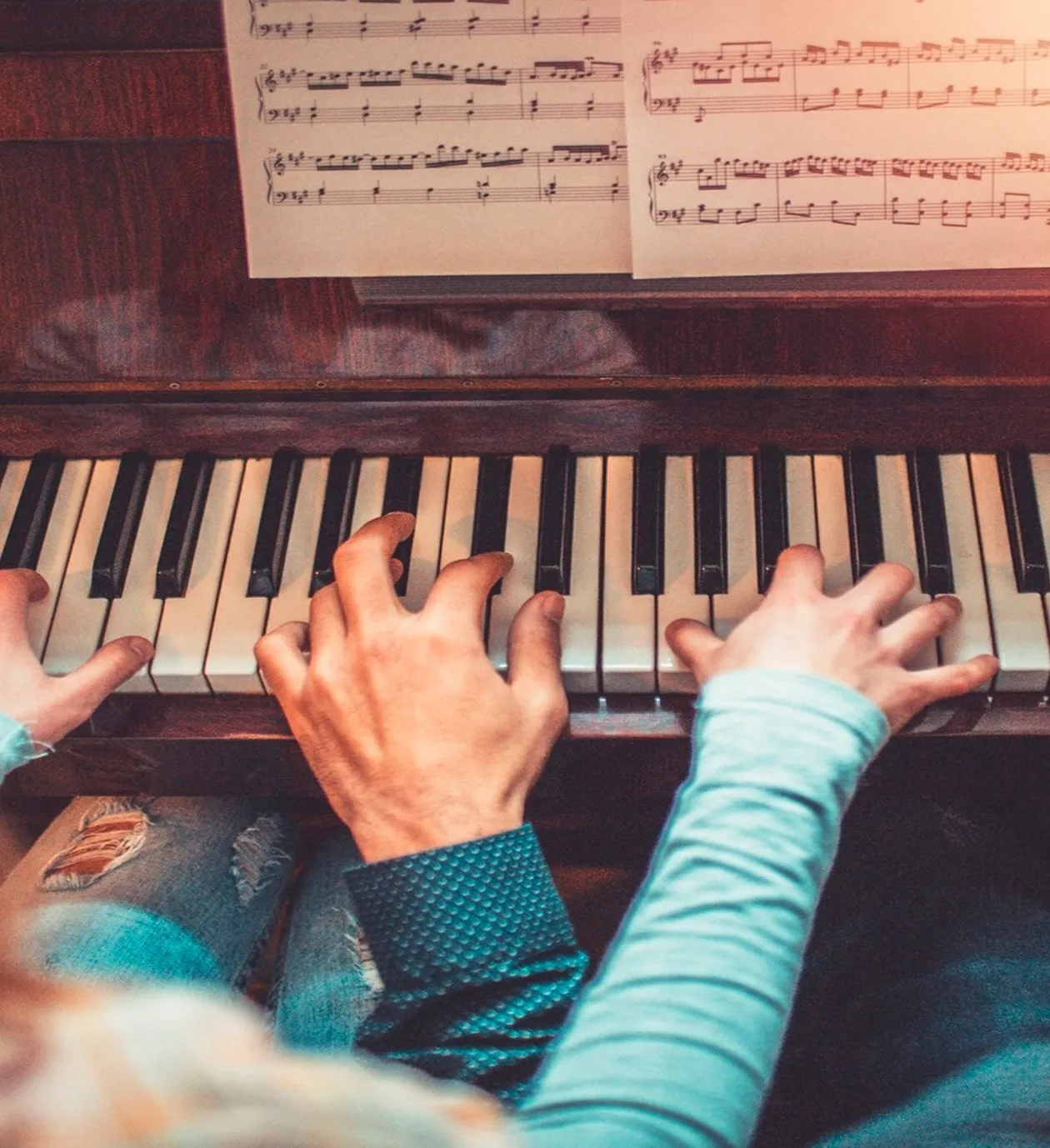 Two people playing piano together