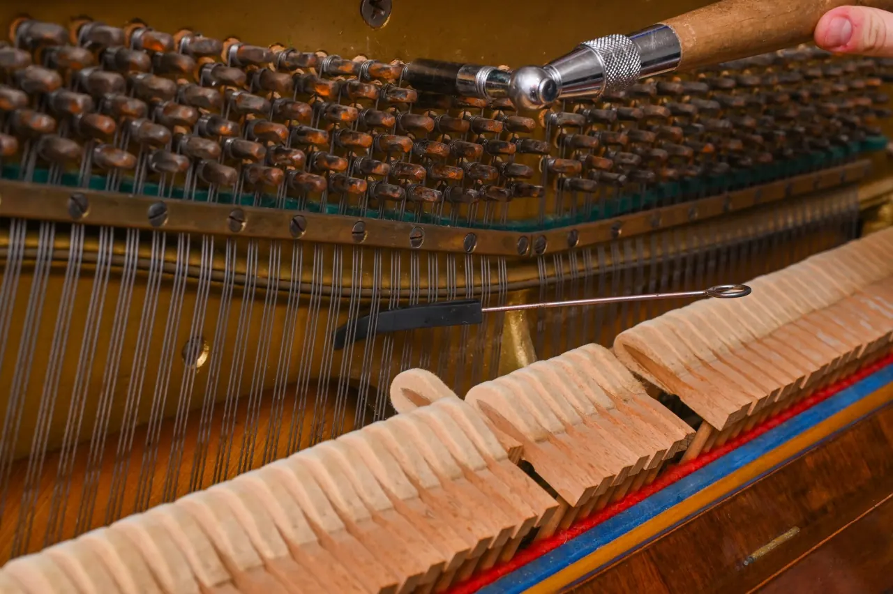 Hand tuning a piano string