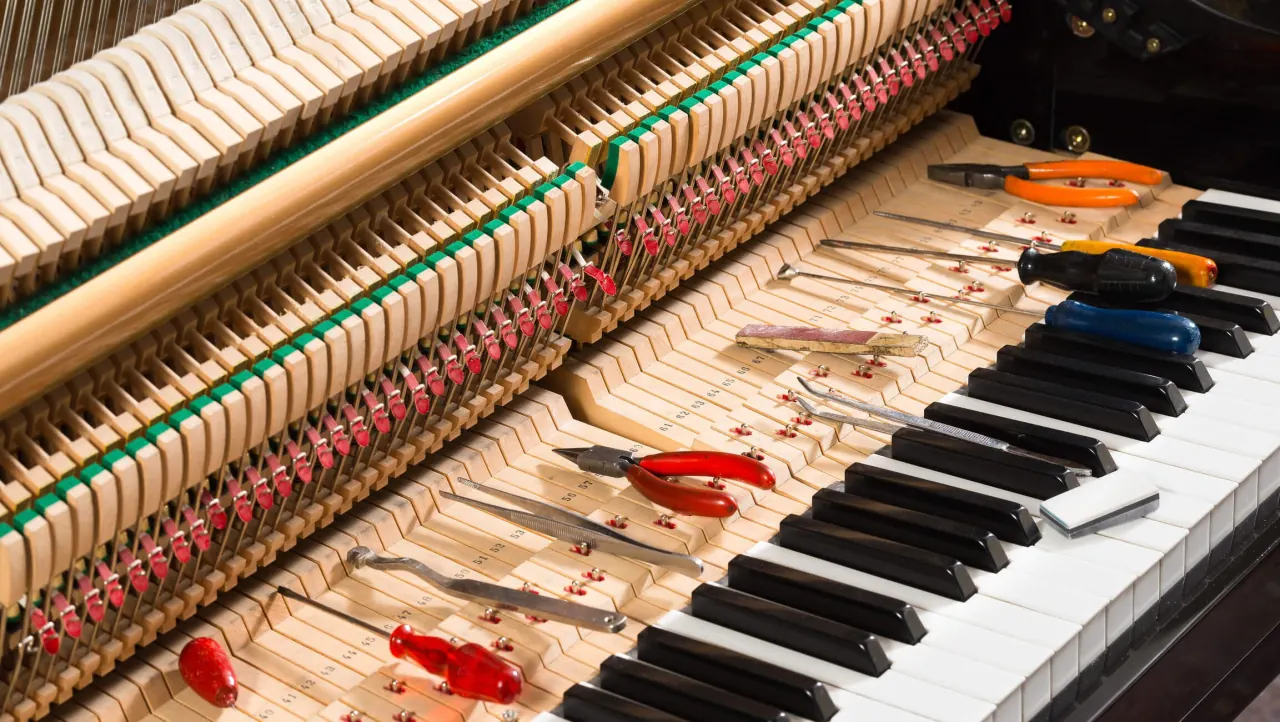 Open piano with repair tools